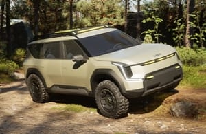 Vehículo de concepto Kia EV9 "ADVNTR" en una vista de tres cuartos, aparcado sobre una gran roca en las montañas.