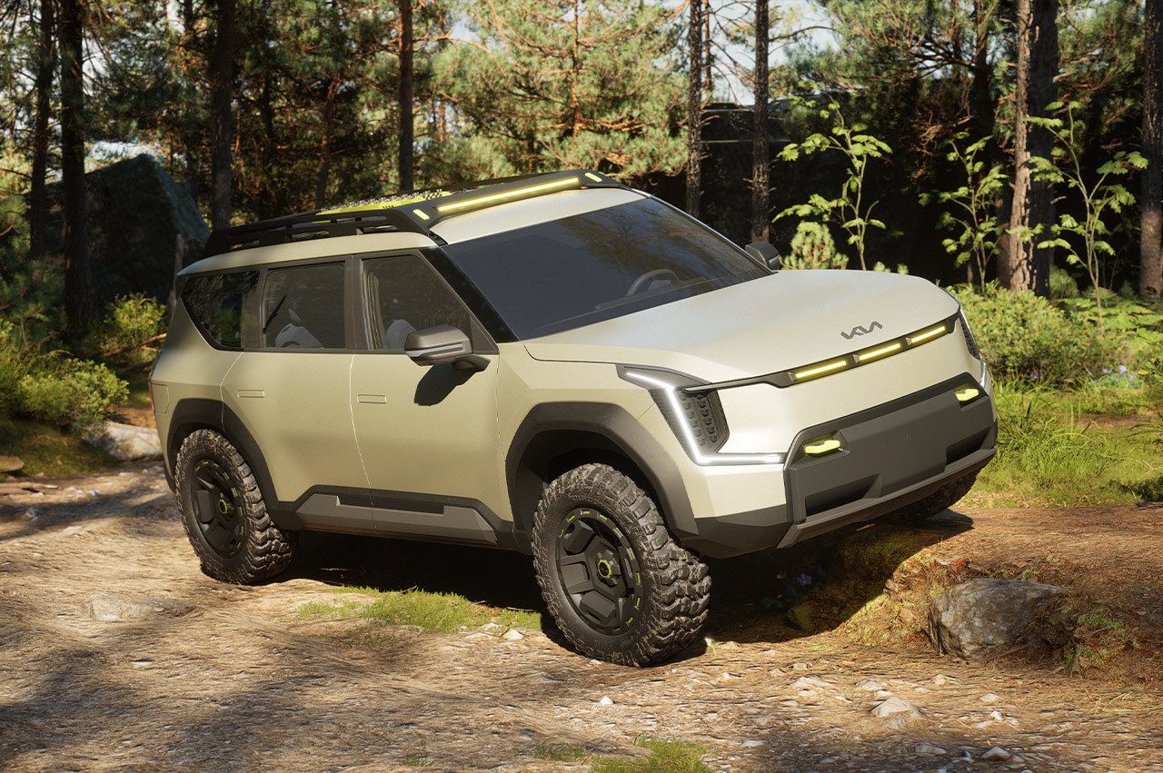 Vehículo de concepto Kia EV9 "ADVNTR" en una vista de tres cuartos, aparcado sobre una gran roca en las montañas.