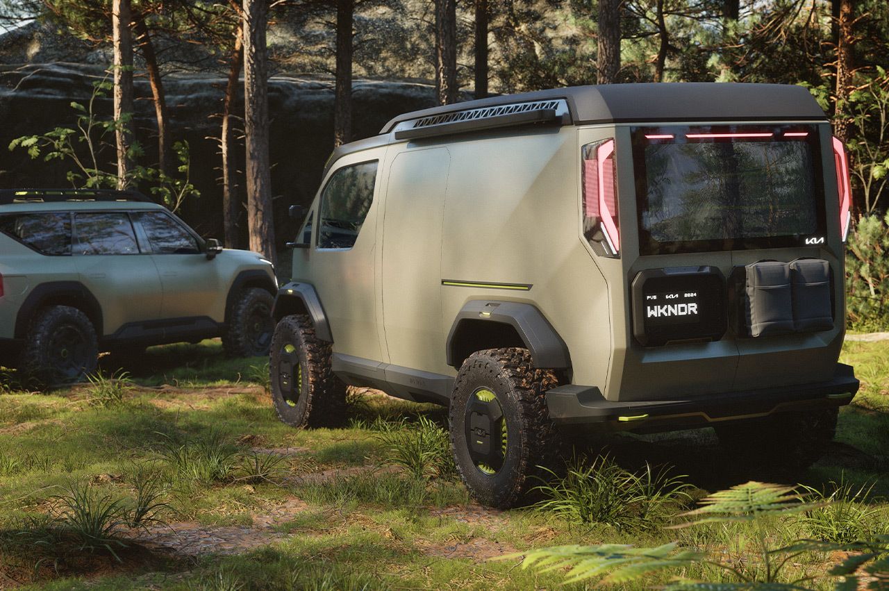 Kia "WKNDR" concept EV van parked adjacent to the "ADVNTR" concept vehicle in the forest