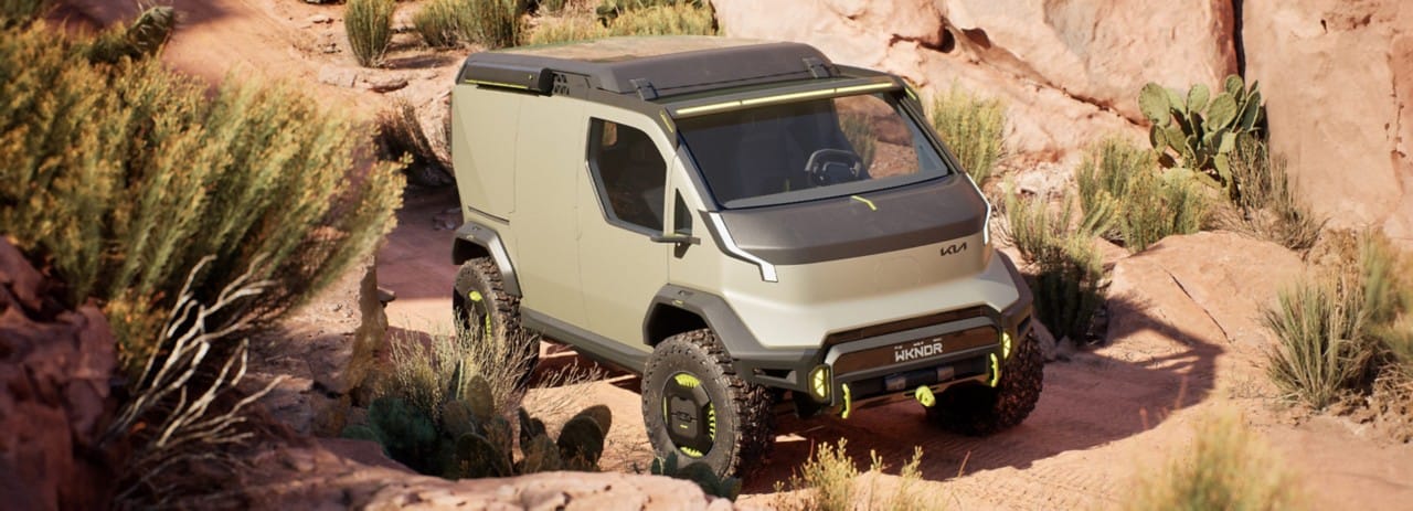 Kia "WKNDR" concept EV van driving over rocky terrain, three-quarter front view