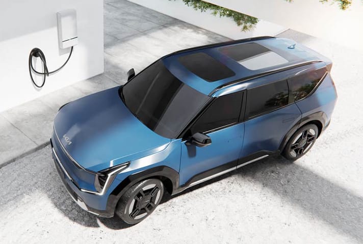 2024 Kia EV9 in blue parked on a home driveway near the Wallbox Quasar 2 energy storage system, bird's eye view